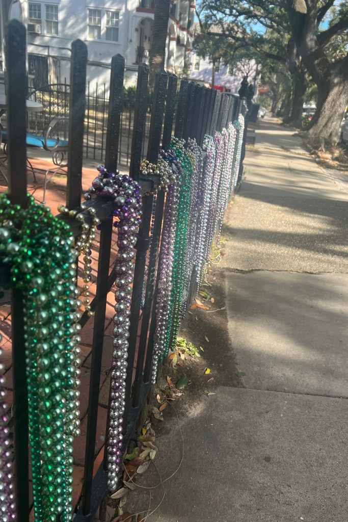 Mardi Gras beads on a wrought iron fence